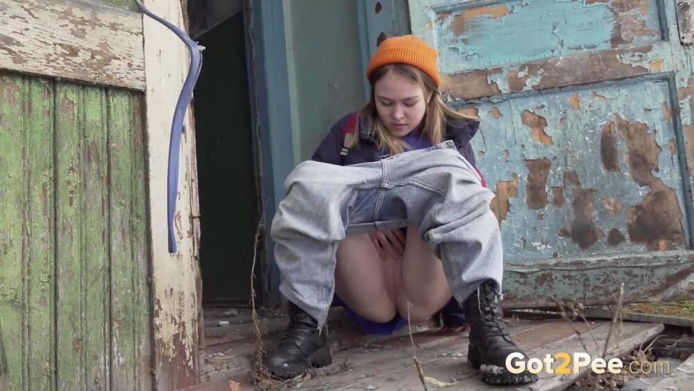 Cute girl pulls down jeans for an urgent piss on the steps of an old building - #5