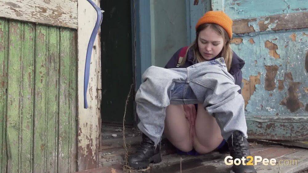 Cute girl pulls down jeans for an urgent piss on the steps of an old building - #11