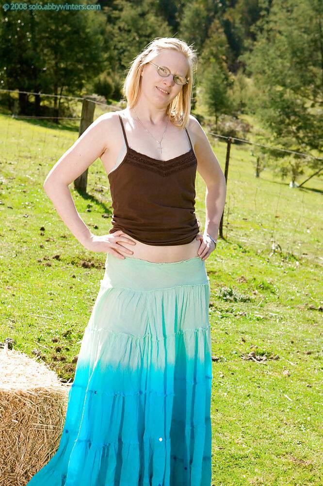 Plain looking blonde girl in glasses strips off blouse and skirt outdoors - #8