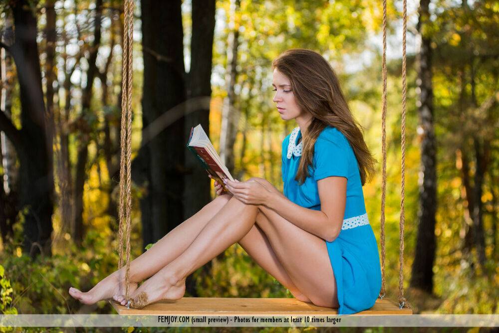 Skinny solo girl Mary Kalisy takes off her dress while reading on a swing - #1