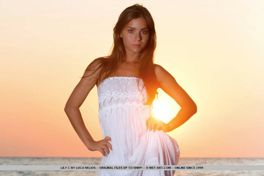 Beautiful teen Lily C takes off her white dress as the sun sets over the ocean - #5