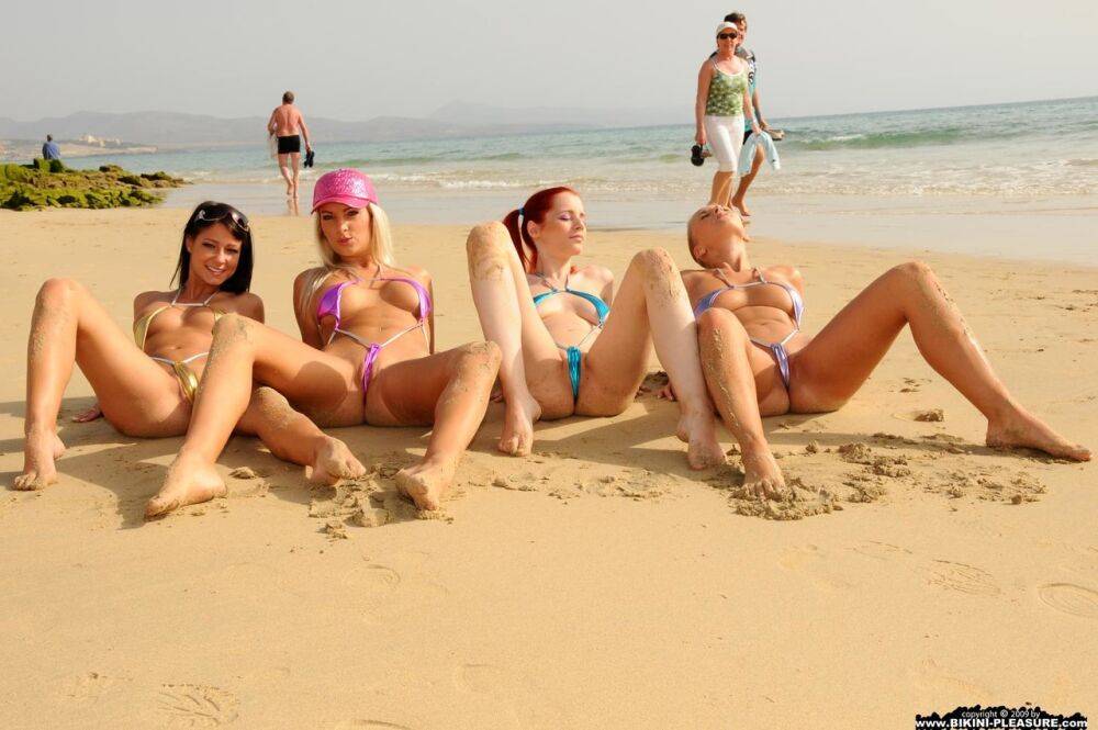 Four girls take off their bikinis to model naked on a public beach - #1