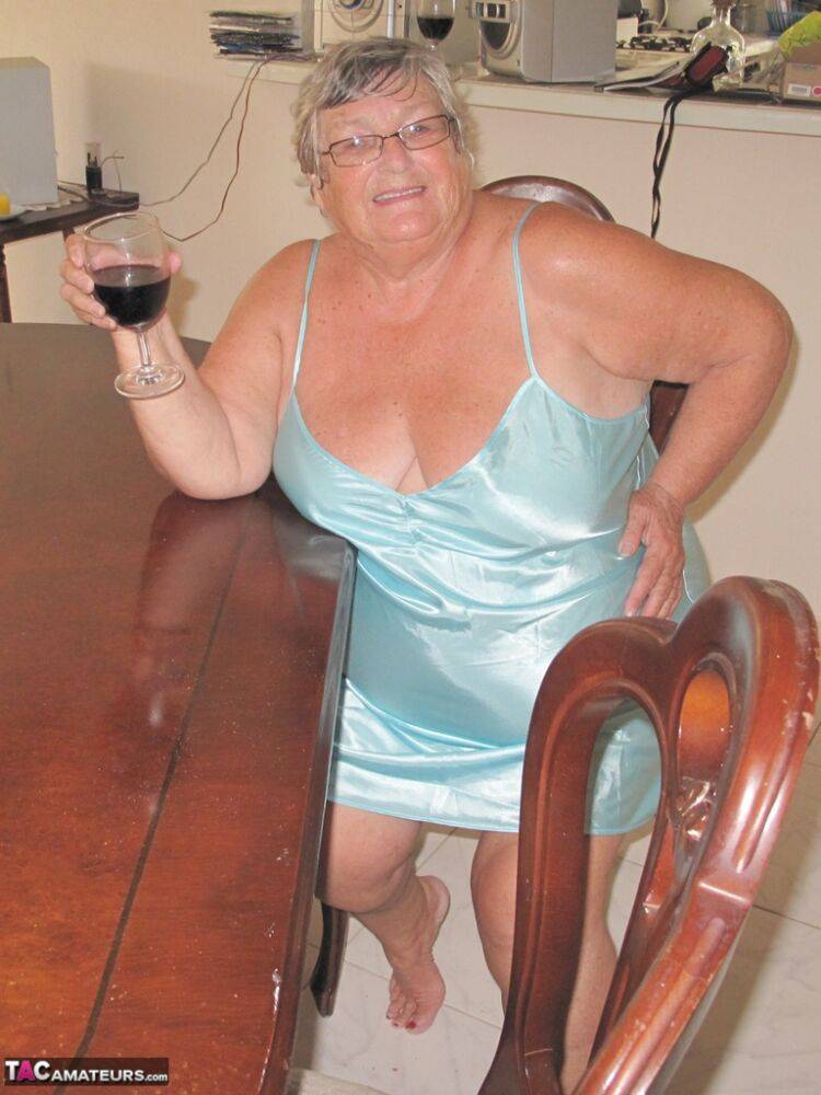 Old British fatty Grandma Libby sticks in a wine bottle in her cunt on a table - #11