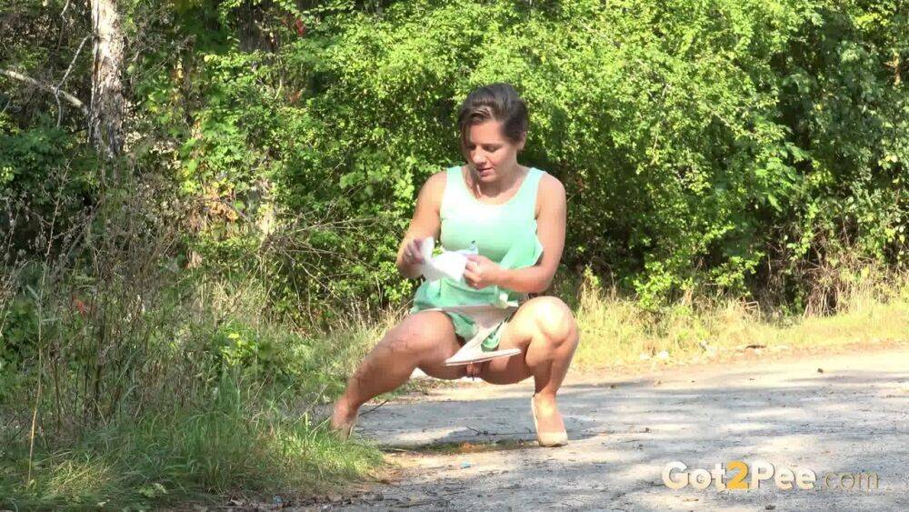 White chick pulls down her panties and squats for a piss on a country path - #1