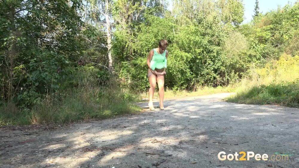 White chick pulls down her panties and squats for a piss on a country path - #6