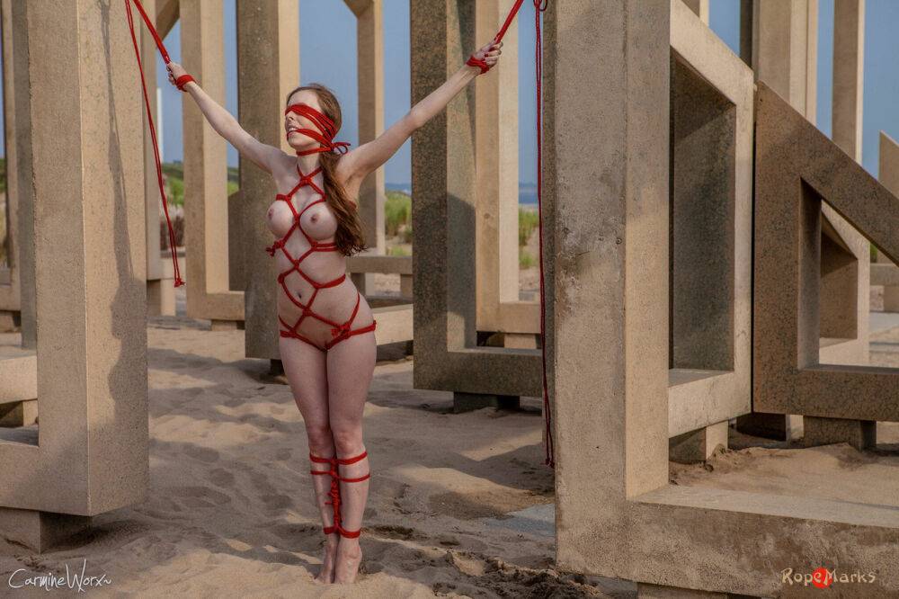 White girl Carmine Worx is tied with ropes to construction beams on a beach - #16