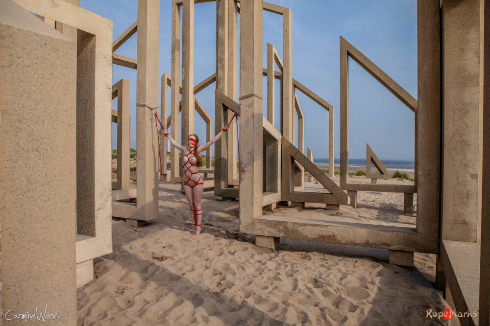 White girl Carmine Worx is tied with ropes to construction beams on a beach - #8