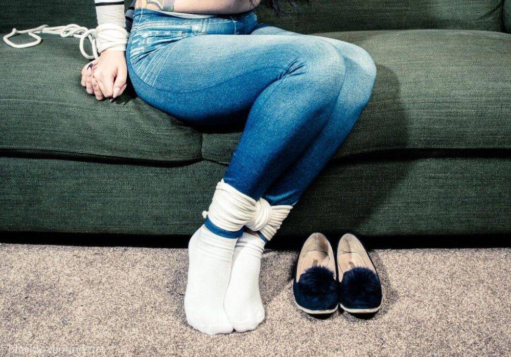 Dark haired chick is hogtied on a couch while closed in jeans and white socks - #10