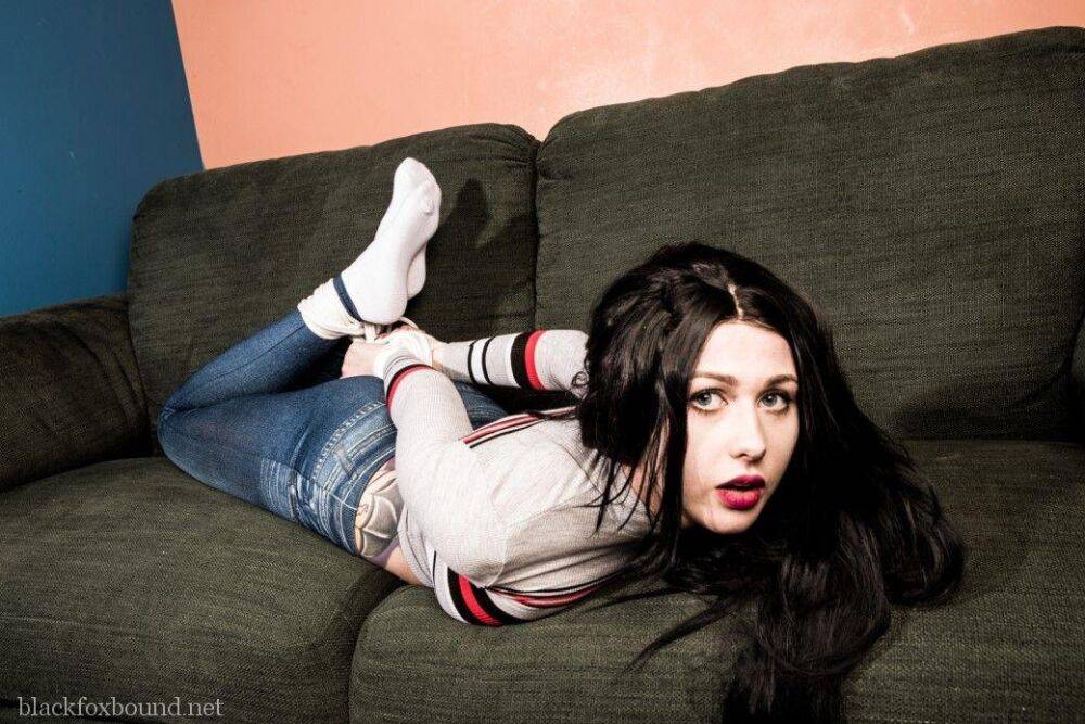 Dark haired chick is hogtied on a couch while closed in jeans and white socks - #3