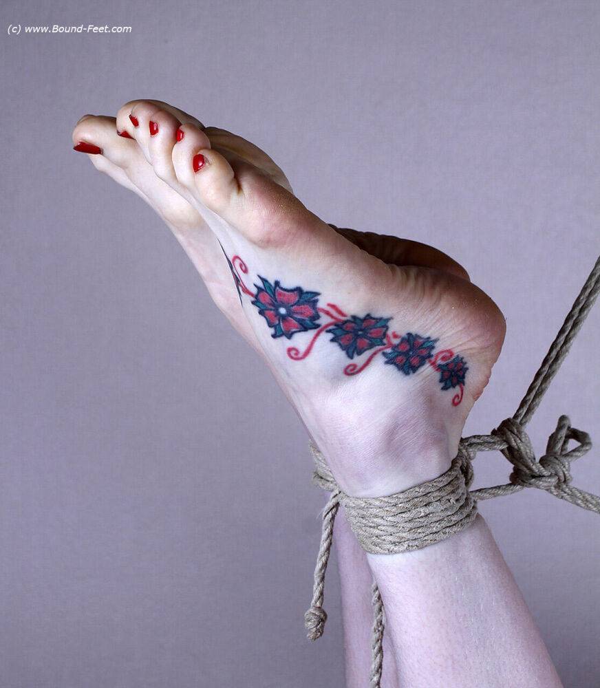 Naked white girl sports tattooed feet while suspended in midair by ropes - #9