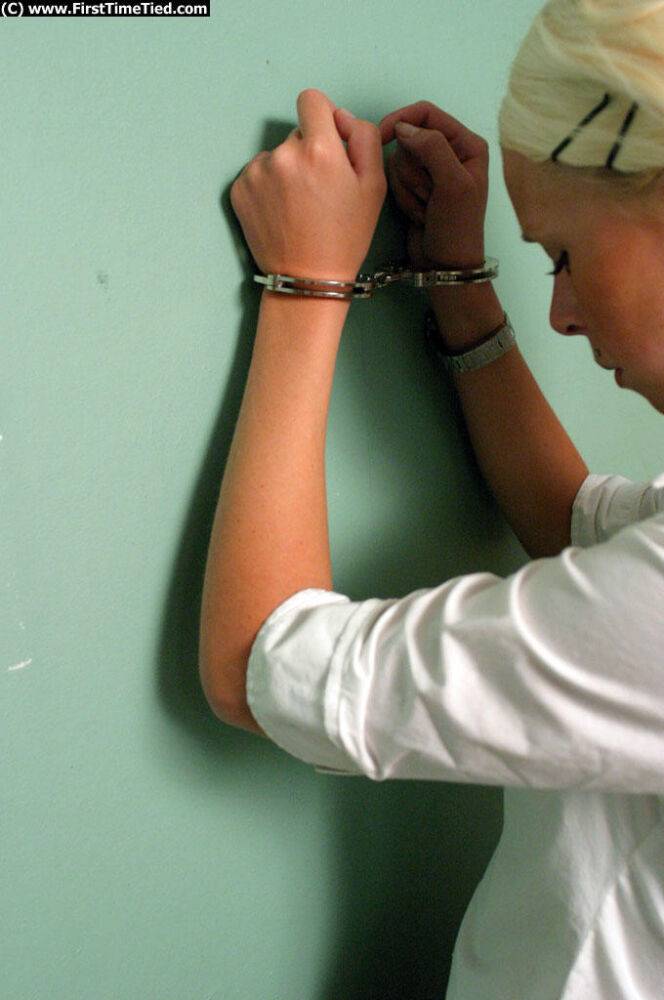 Blonde girl in a black skirt and white blouse is placed in handcuffs - #10