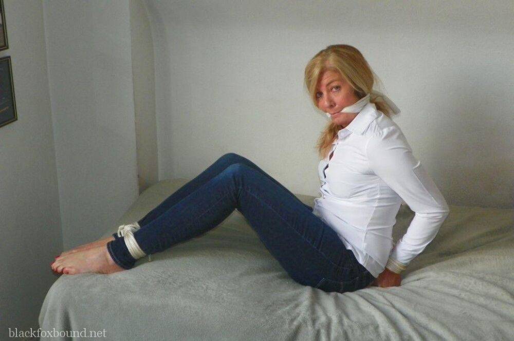 Blonde woman is cleave gagged and hogtied in a white blouse and blue jeans - #7