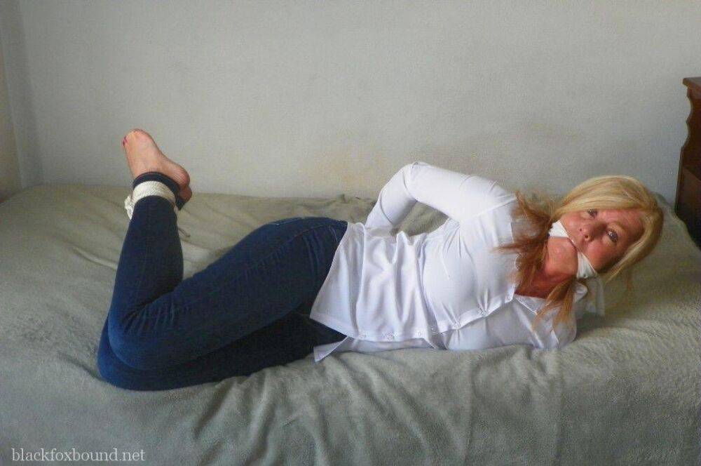 Blonde woman is cleave gagged and hogtied in a white blouse and blue jeans - #12