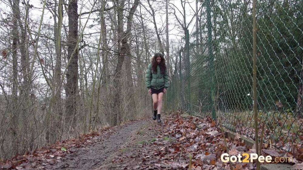 White girl Ali Bordeaux squats for a piss against a fence in a winter coat - #9