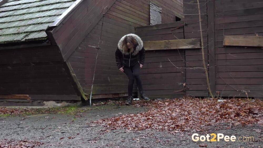 White girl Cynthia Vellons squats to take a piss next to an isolated building - #8