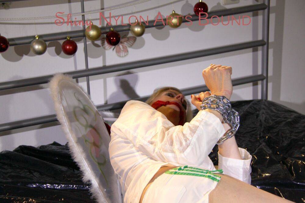 Pia tied and gagged on a bed with cuffs wearing a sexy white shiny nylon - #16