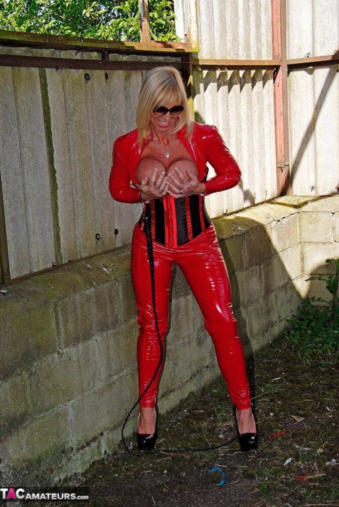 Hot older blonde Melody displays her big tits in red latex clothing and shades - #16