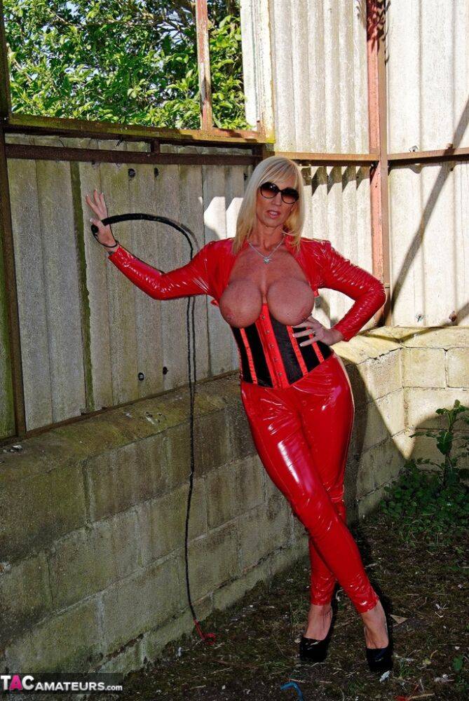 Hot older blonde Melody displays her big tits in red latex clothing and shades - #12