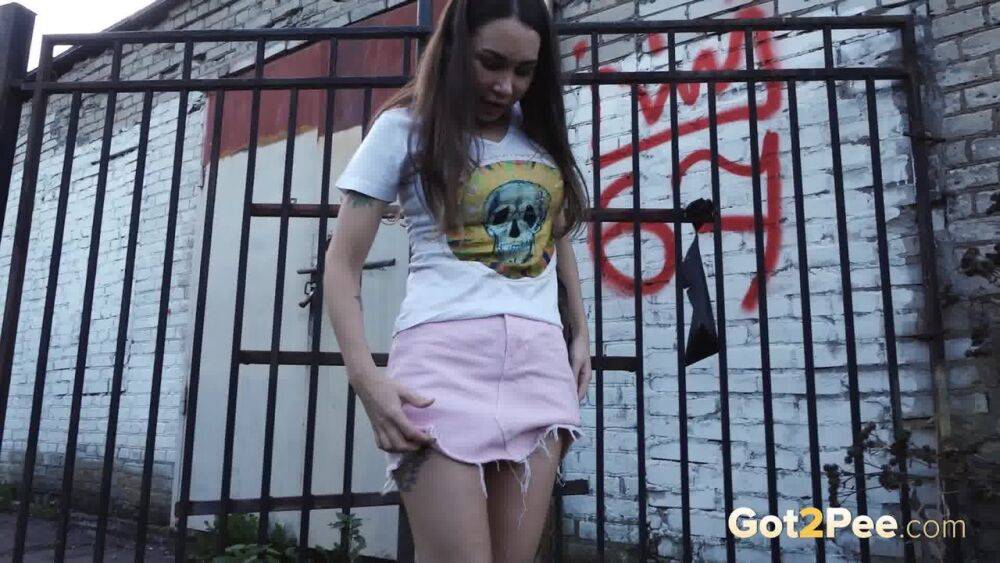 Distressed girl Sasha S lifts up a skirt before taking a pee behind a building - #1