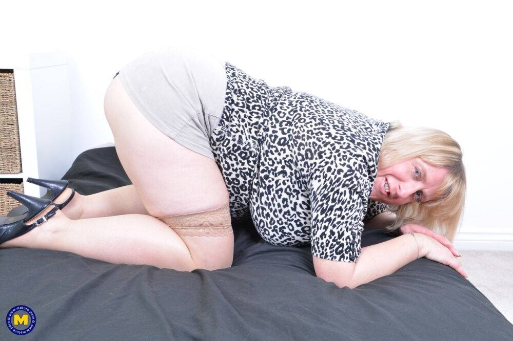 Mature BBW unleashes her huge tits as she strips to sheer stockings on a bed - #4
