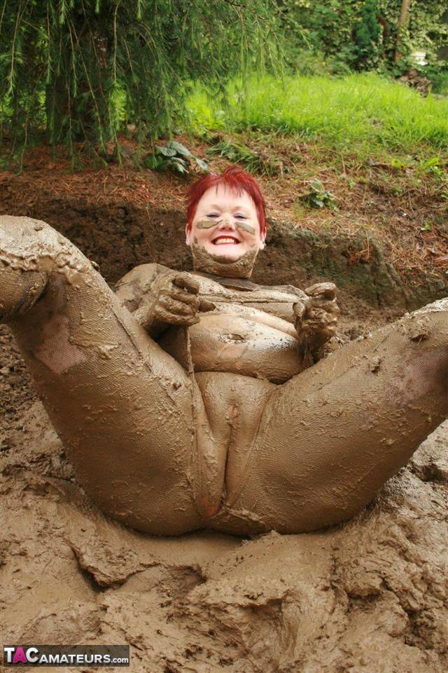 Older redhead Valgasmic Exposed rolls around in a mud pit while totally naked - #2