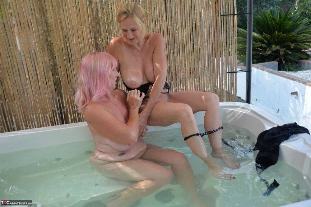 Older lesbians play with each other while in an outdoor hot tub - #11