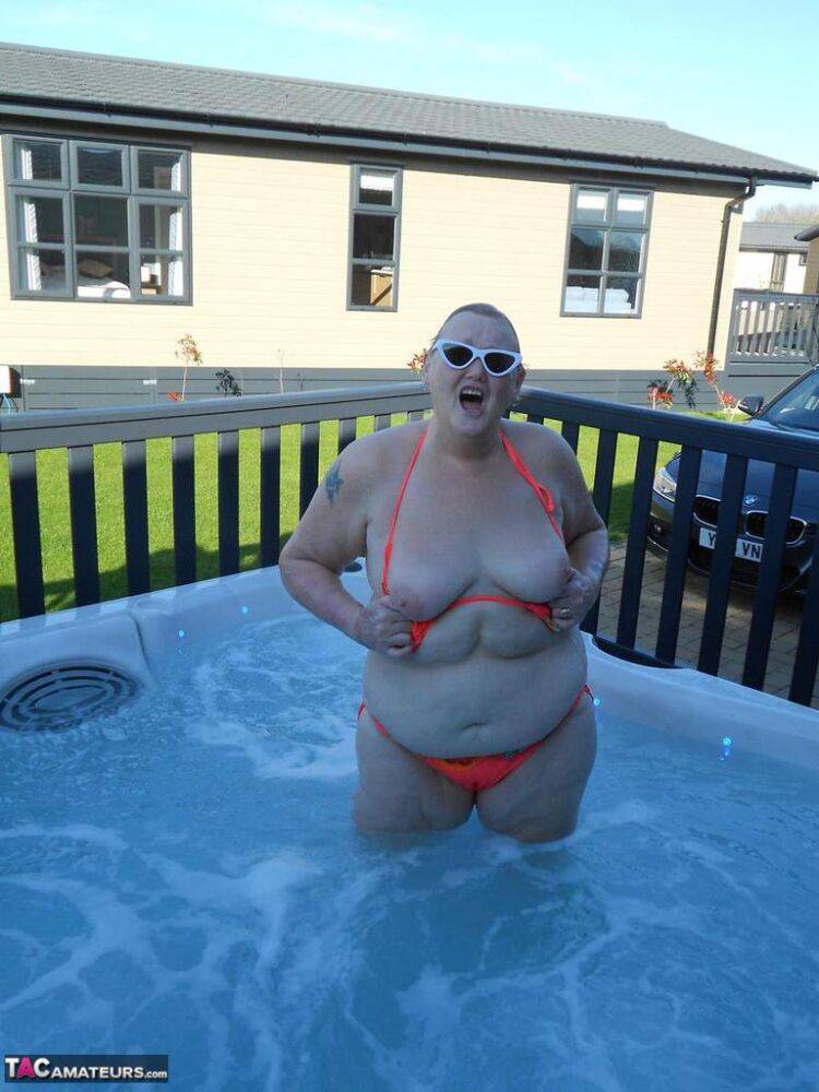 Fat nan bares her boobs while in a patio hot tub before getting naked on a bed - #3