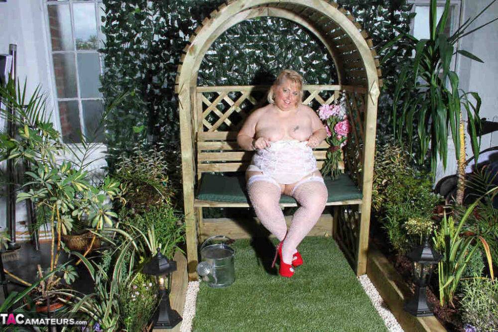 Fat blonde Lexie Cummings dildos her pierced pussy in a garden setting | Photo: 4389012