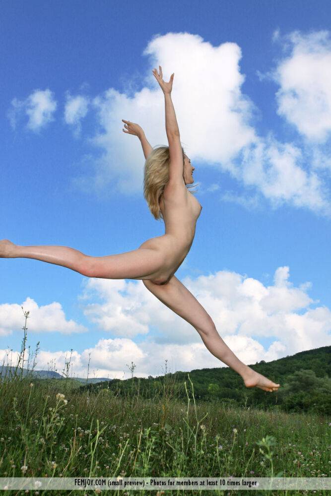 Thin blonde Thea C shows off her flexibility while posing naked in a field - #9