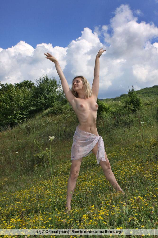 Thin blonde Thea C shows off her flexibility while posing naked in a field - #2