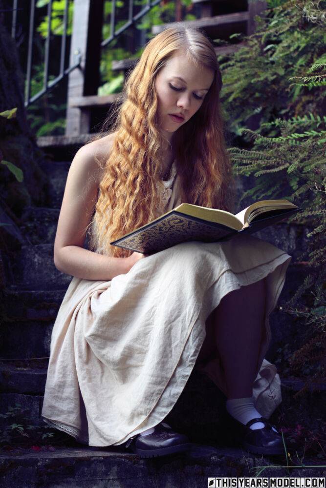 Young redhead Dolly Little exposes herself on garden steps while reading - #6