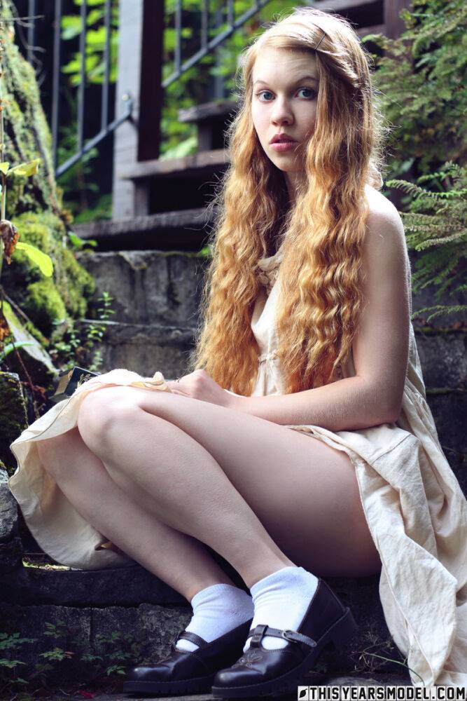 Young redhead Dolly Little exposes herself on garden steps while reading - #10