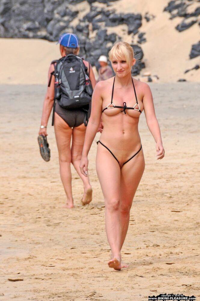 Hot blonde removes a skimpy bikini during a visit to a public beach - #16