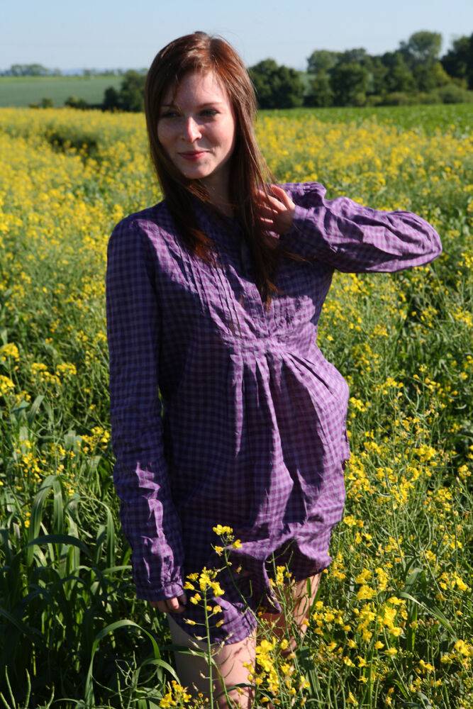 Young redhead gets completely naked in a field of Rapeseed - #8