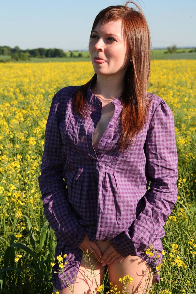 Young redhead gets completely naked in a field of Rapeseed - #3