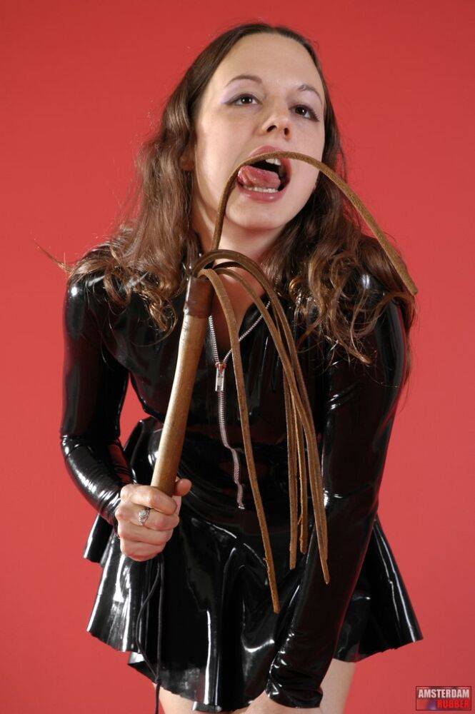 Solo girl wields a flogger while wearing latex clothing and boots - #13