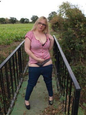 Amateur BBW Sindy Bust exposes her big boobs and twat on a countryside bridge on pornstar6.com