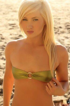 Young looking blonde girl Ashlie Madison cups her flat chest via bikini top on pornstar6.com