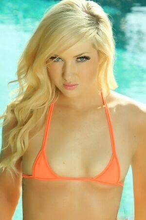 Petite blonde Ashlie Madison models non nude in skimpy bikini by pool on pornstar6.com