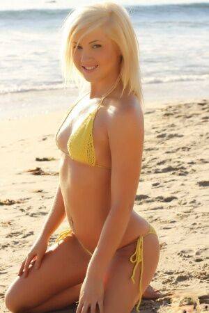 Blonde glamour model Ashlie Madison poses alone on a beach in a yellow bikini on pornstar6.com