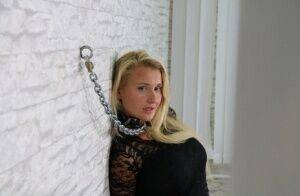 Fully clothed blonde is fastened to a wall with chains in handcuffs on pornstar6.com