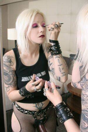 Tattooed blonde rocker Cindy B does her makeup while wearing a strapon cock on pornstar6.com