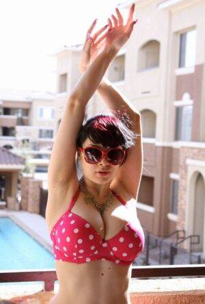 Amateur girl Susy Rocks models a polka-dot bikini in shades on a balcony on pornstar6.com