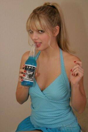 Young blonde Jana Jordan covers up her naked breasts while drinking blue soda - Jordan on pornstar6.com