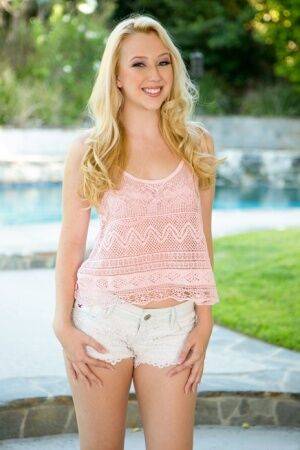 Cute blonde Samantha Rone stands naked after disrobing on a backyard walkway on pornstar6.com