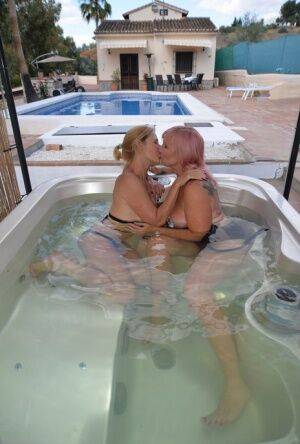 Mature lesbians with big tits kiss in a hot tub before licking pussy on pornstar6.com