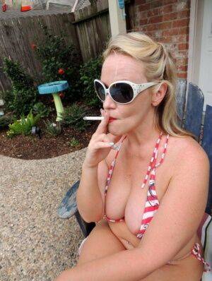 Fat blonde Dee Siren smokes while taking off a bikini in the backyard on pornstar6.com