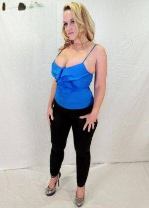 Middle-aged blonde Dee Siren displays her ample cleavage in tight pants on pornstar6.com