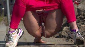 White girl Barbara Bieber pulls down pink leggings to piss on a sidewalk on pornstar6.com