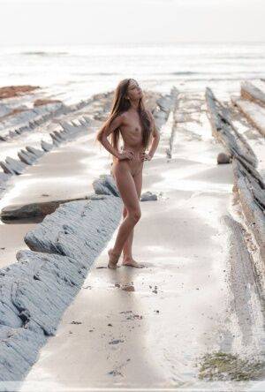 Slim girl Lorena G models totally naked on a seaside rock formation on pornstar6.com